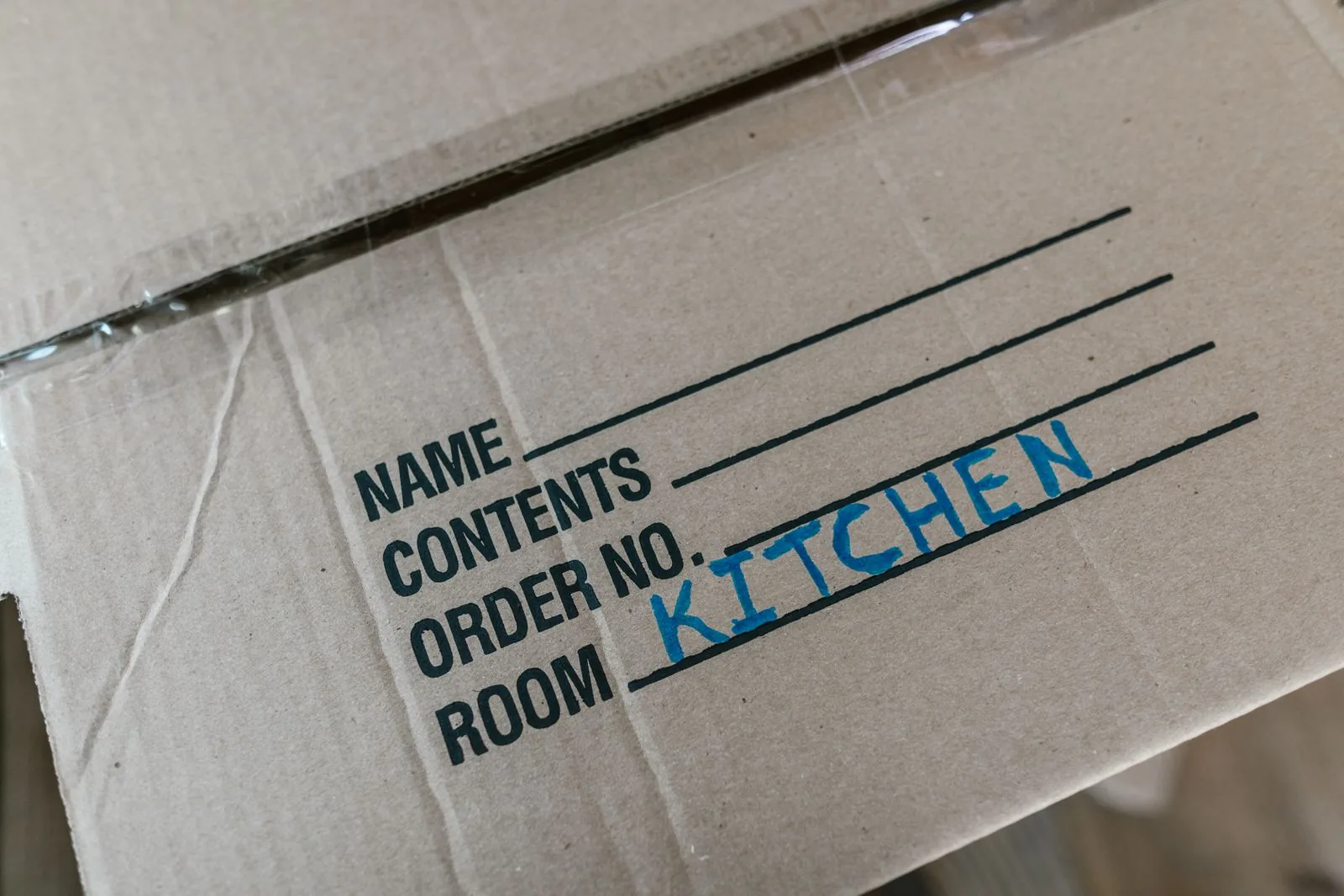 Close-up of a moving box labeled for the kitchen